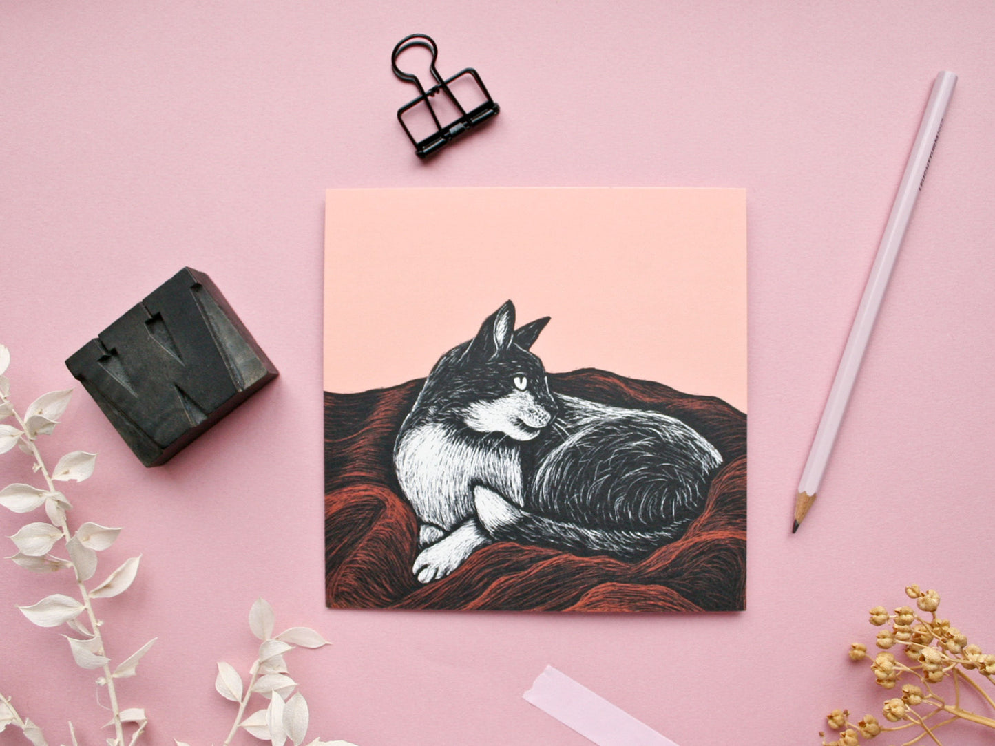 Quadratische Postkarte Katze auf Decke