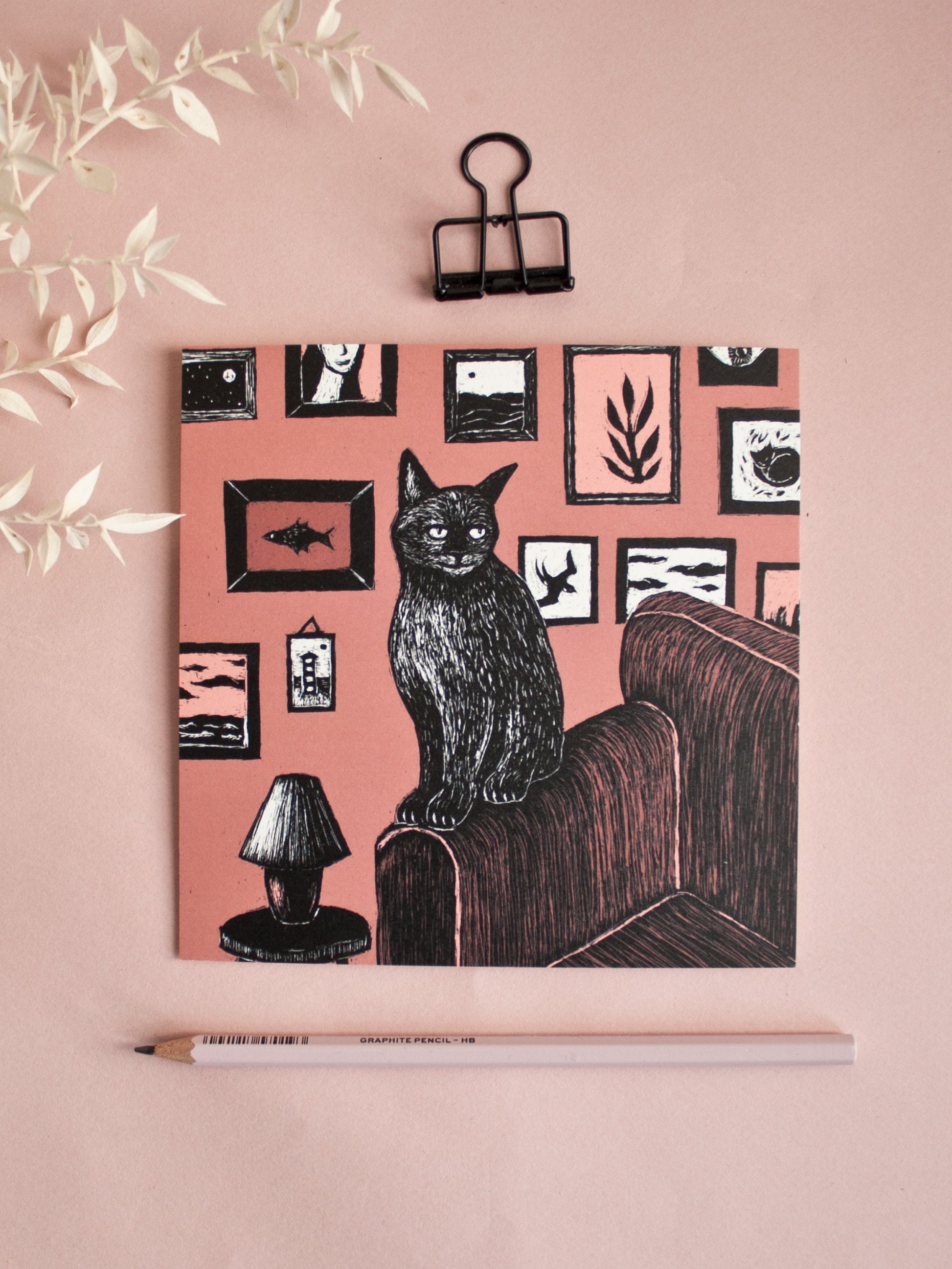 Quadratische Postkarte Katze vor Bilderwand